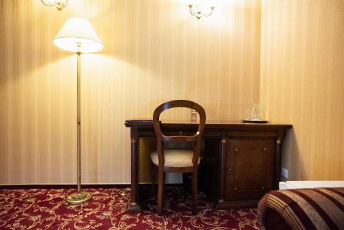 a room with a desk with a chair and a lamp at Solva Resort Medical & SPA in Polyana