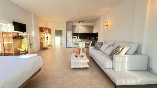 a living room with a white couch and a kitchen at Estudio Frente al Canal con Terraza in Empuriabrava