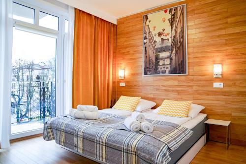 a bedroom with a bed with two towels on it at Prince Apartment by Baltic Home in Świnoujście
