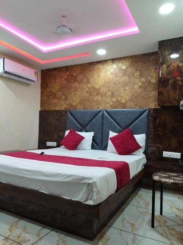 a bedroom with a large bed with red pillows at Hotel Raj Palace in Ahmedabad