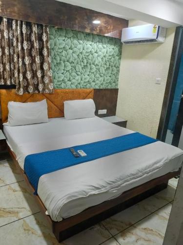 a bedroom with a large bed with a blue blanket at Hotel Raj Palace in Ahmedabad