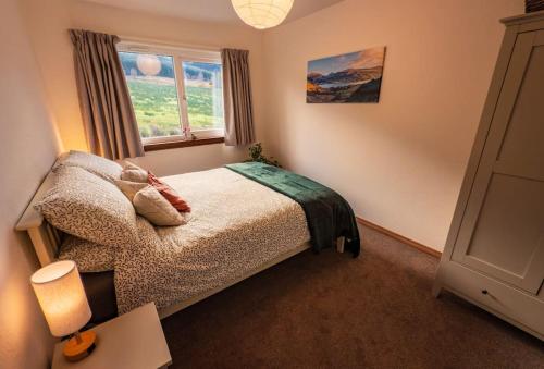a bedroom with a bed and a window at Sachsblick in Lochgoilhead