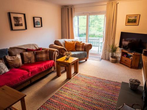 a living room with two couches and a tv at Sachsblick in Lochgoilhead