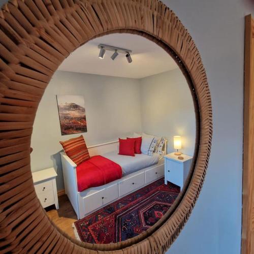 a bedroom with a bed and a round mirror at Sachsblick in Lochgoilhead