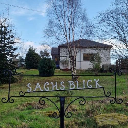 a sign in a yard in front of a house at Sachsblick in Lochgoilhead