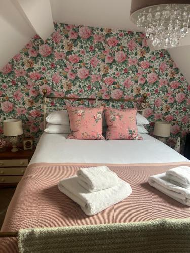a bedroom with a bed with a floral wall at Bell Cottage right in the heart of Bridgnorth in Bridgnorth