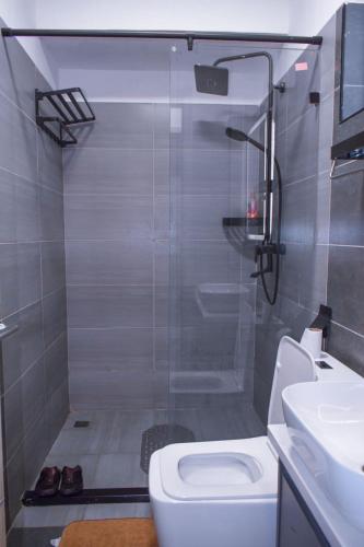 a bathroom with a shower with a toilet and a sink at Haydenco Suites Furnished Studios in Nairobi