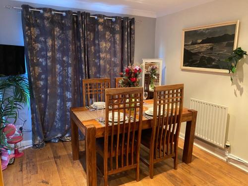 a dining room with a wooden table and chairs at Harbury Lodge in Scotstoun West Station