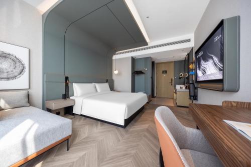 a hotel room with a bed and a flat screen tv at Atour S Hotel Chongqing Yubei Central Park in Yubei