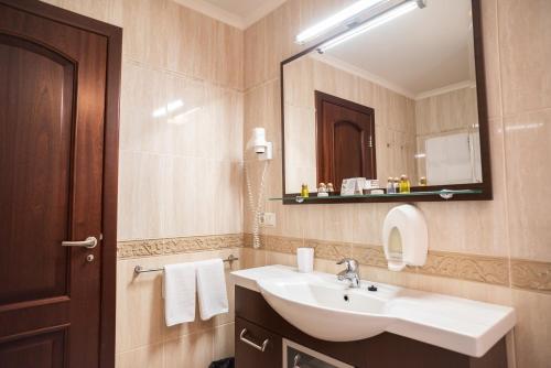 a bathroom with a sink and a mirror at Solva Resort Medical & SPA in Polyana