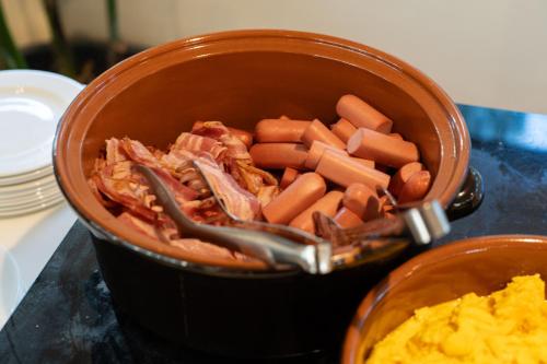 a pot filled with carrots and meat next to a bowl of eggs at Club del Sole Adriano Family Collection in Punta Marina