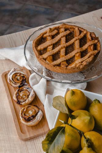 a pie on a glass plate next to a plate of lemons at Controvento in La Maddalena