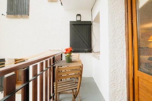 a balcony with a wooden table and a vase of flowers at Villa Garmet Formigal in Formigal