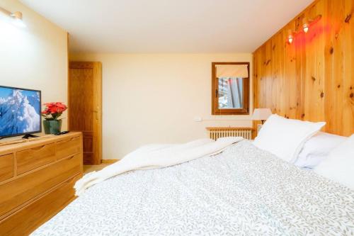 a bedroom with a white bed and a television at Villa Garmet Formigal in Formigal