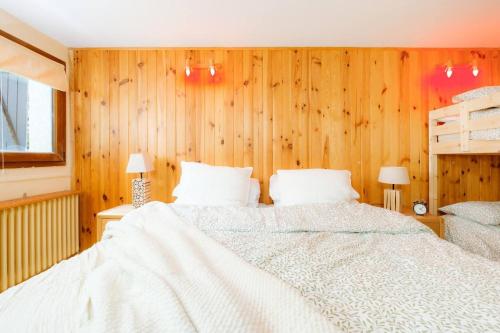 a bedroom with a white bed and wooden walls at Villa Garmet Formigal in Formigal