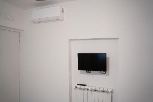 a flat screen tv hanging on a white wall at A Casa di Elsa in Sonnino