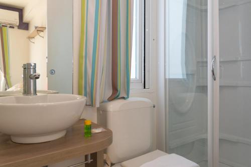 a bathroom with a toilet and a sink and a shower at Club del Sole Adriano Family Collection in Punta Marina