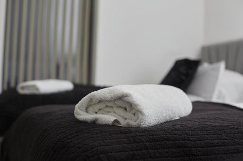 a white towel sitting on top of a bed at BV Aparthotel Stays in the Heart of Barnsley Town Centre in Barnsley