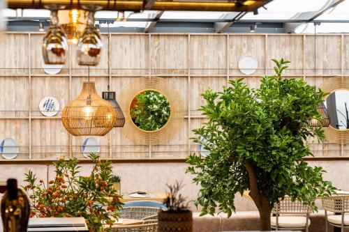a restaurant with a wall with potted plants and lights at Villa Promenade in Burgas City
