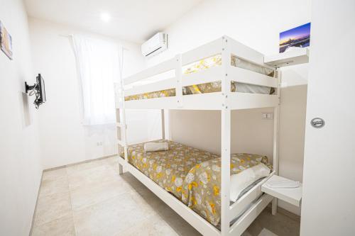 a white bunk bed in a white room with a bed at Villa Lumia in Tre Fontane