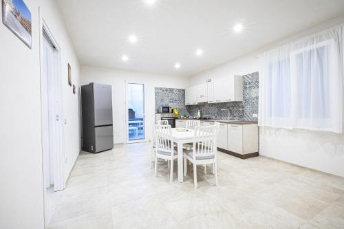 a kitchen with a table and chairs and a refrigerator at Villa Lumia in Tre Fontane