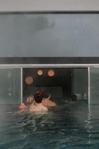 a group of people in a swimming pool at Hotel Tauernhof in Grossarl