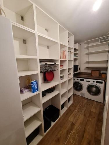 a laundry room with white shelves and a washing machine at Magnifique maison in Valenton