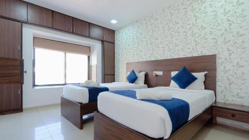 a bedroom with two beds and a window at Magnus Aerith Studios Exclusive Residences in Pune
