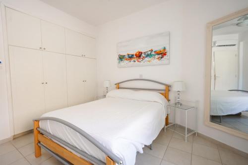 a white bedroom with a bed and a mirror at Resitour - Tala Hills in Tala