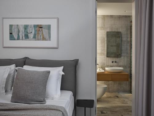 une chambre avec un lit et une salle de bain avec un lavabo dans l'établissement 270 Sea Villa, Panoramic Splendor Crete, à Agios Nikolaos