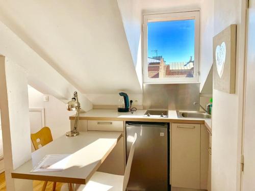 une petite cuisine avec un évier et une fenêtre dans l'établissement Studio Renovated Chic Location, à Nice