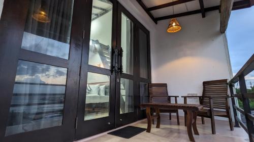 een balkon met een tafel, stoelen en een raam bij Surf edge villa in Mawella
