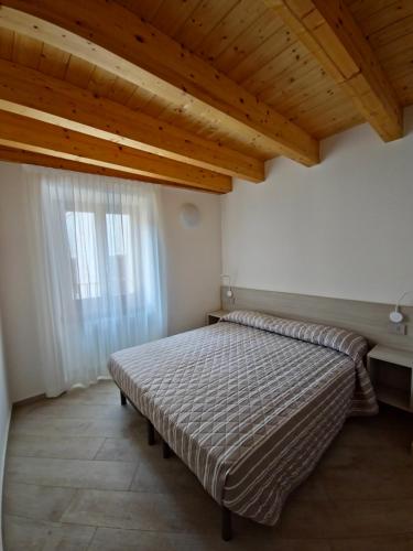 a bed in a room with a wooden ceiling at casa antico borgo - appartamento 1 in Assenza di Brenzone