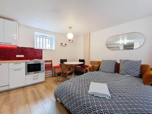 Cet appartement comprend une chambre avec un lit, une cuisine et une table. dans l'établissement T2 Cosy - Hypercentre - NEW SOFA BED - Cathédrale - Carré d'OR, à Strasbourg