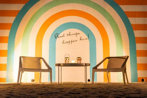 two chairs and a table in front of a rainbow at Setouchi Island Stays Suo Oshima in Suo Oshima