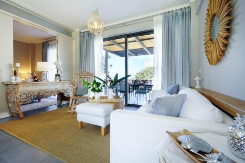 a living room with a white couch and a table at Urban Living Homes, with Jaccuzi in Agios Onoufrios