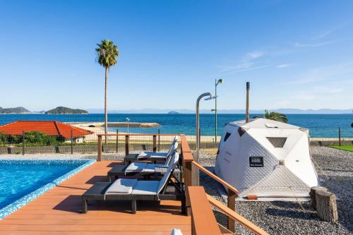 a luxury villa with a swimming pool and a boat at Setouchi Island Stays Suo Oshima in Suo Oshima