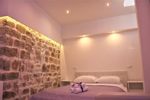a bedroom with a bed and a stone wall at Medulić Palace Rooms & Apartments 2 in Šibenik