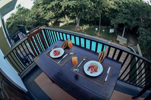 a table with two plates of food on a balcony at Hotel Golden Ray in Dambulla