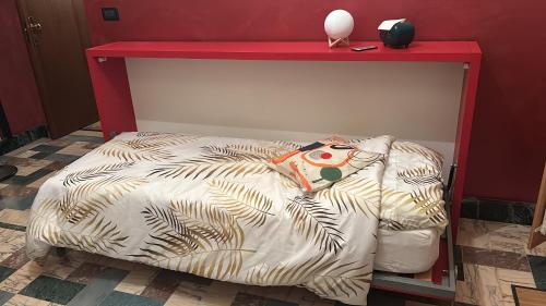 a bed in a room with a red shelf at Cuneo Centro Affittacamere in Cuneo