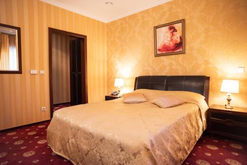a bedroom with a large bed with two night stands and two lamps at Solva Resort Medical & SPA in Polyana