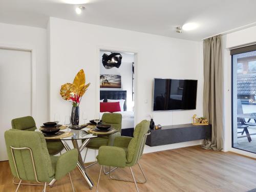 a dining room with a table and chairs and a television at Klein und fein mit Whirlpool in Burgwedel