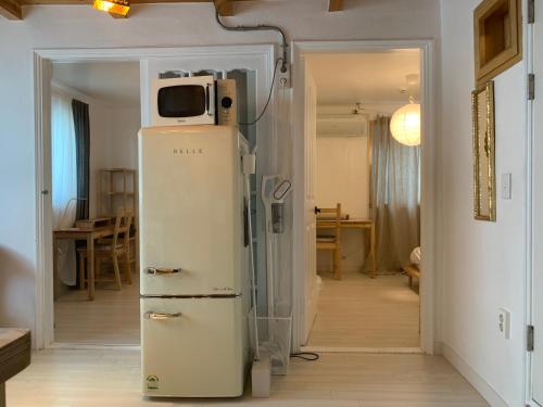 a refrigerator with a microwave on top of it in a room at liilliil Residence Seoul in Seoul