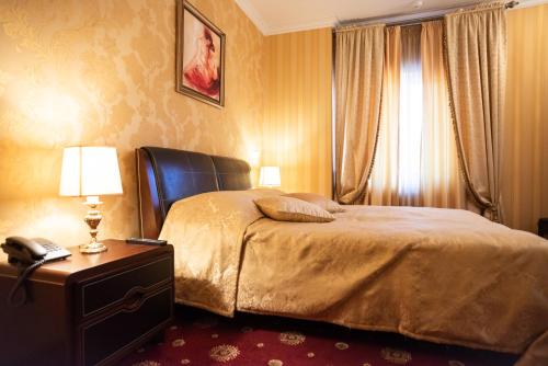 a bedroom with a bed and a telephone and a window at Solva Resort Medical & SPA in Polyana