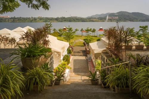 a row of tents in front of a body of water at RiverView Tent Resort in Kevadia