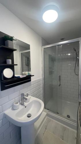 a white bathroom with a sink and a shower at Papa guest in Poole