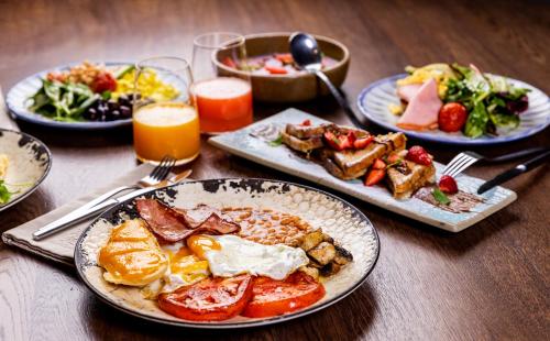 a table with plates of breakfast food and drinks at Villa Promenade in Burgas City