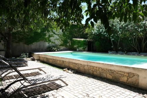 une piscine avec deux chaises longues à côté dans l'établissement charming provencal house with private pool for 4 people in cheval blanc, luberon., à Cheval-Blanc