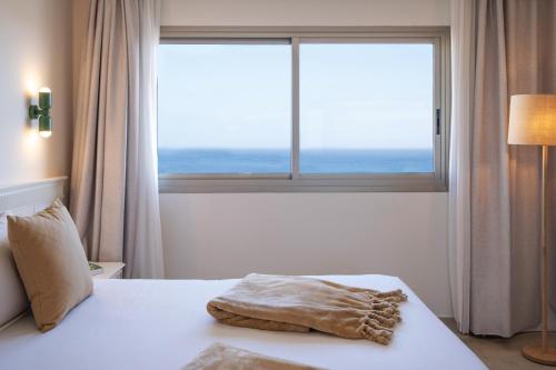 a bedroom with a bed with a large window at Iberostar Waves Gaviotas Park in Morro del Jable
