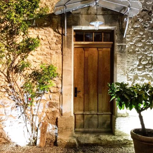 - une porte en bois sur le côté d'un bâtiment en pierre dans l'établissement superb prestigious mas with pool in the countryside of caumont sur durance, close to avignon, sleeps 8, à Caumont-sur-Durance
